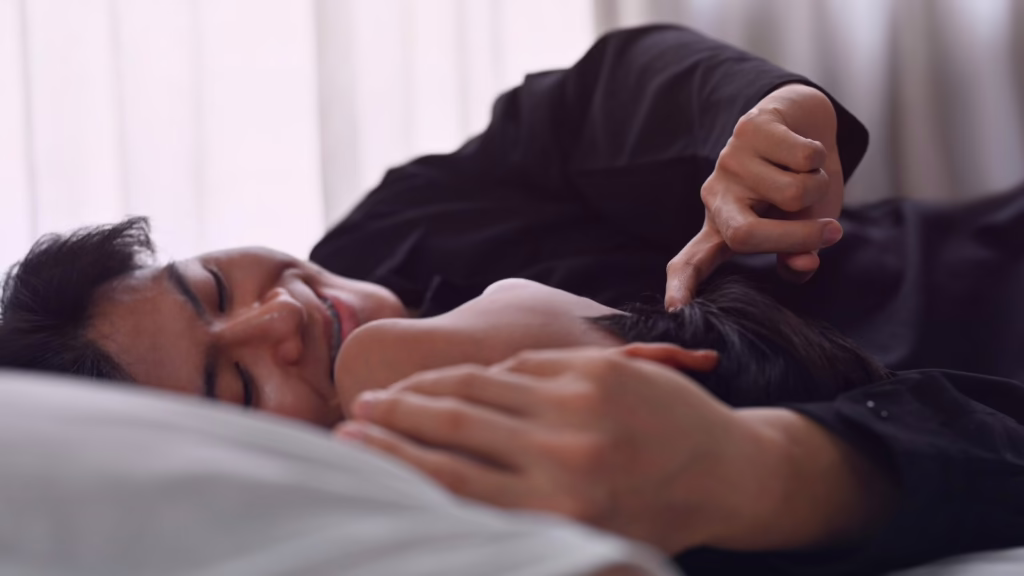 A couple cuddling in bed